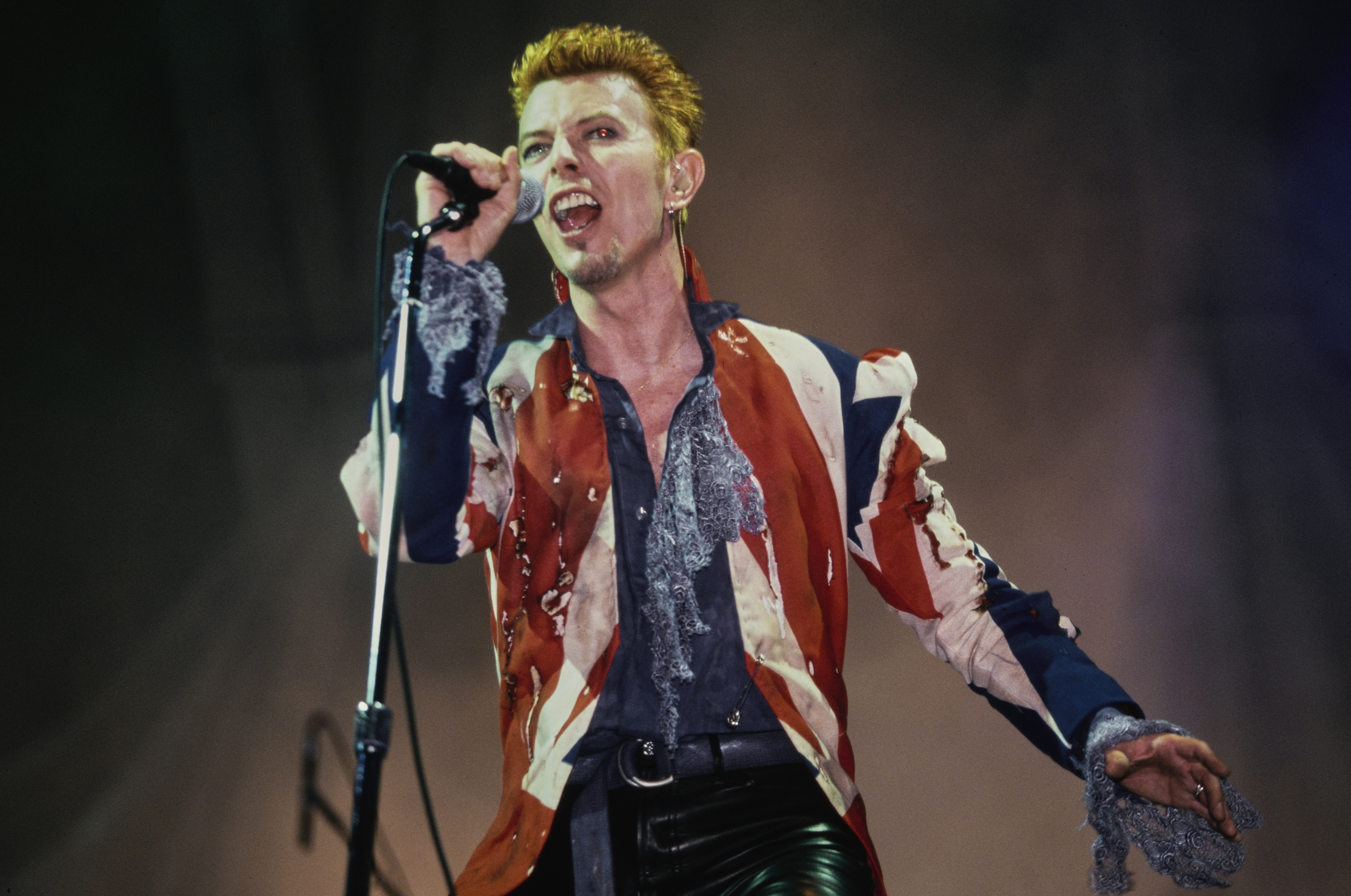 David Bowie performing live at the Phoenix Festival, wearing a Union Jack jacket.