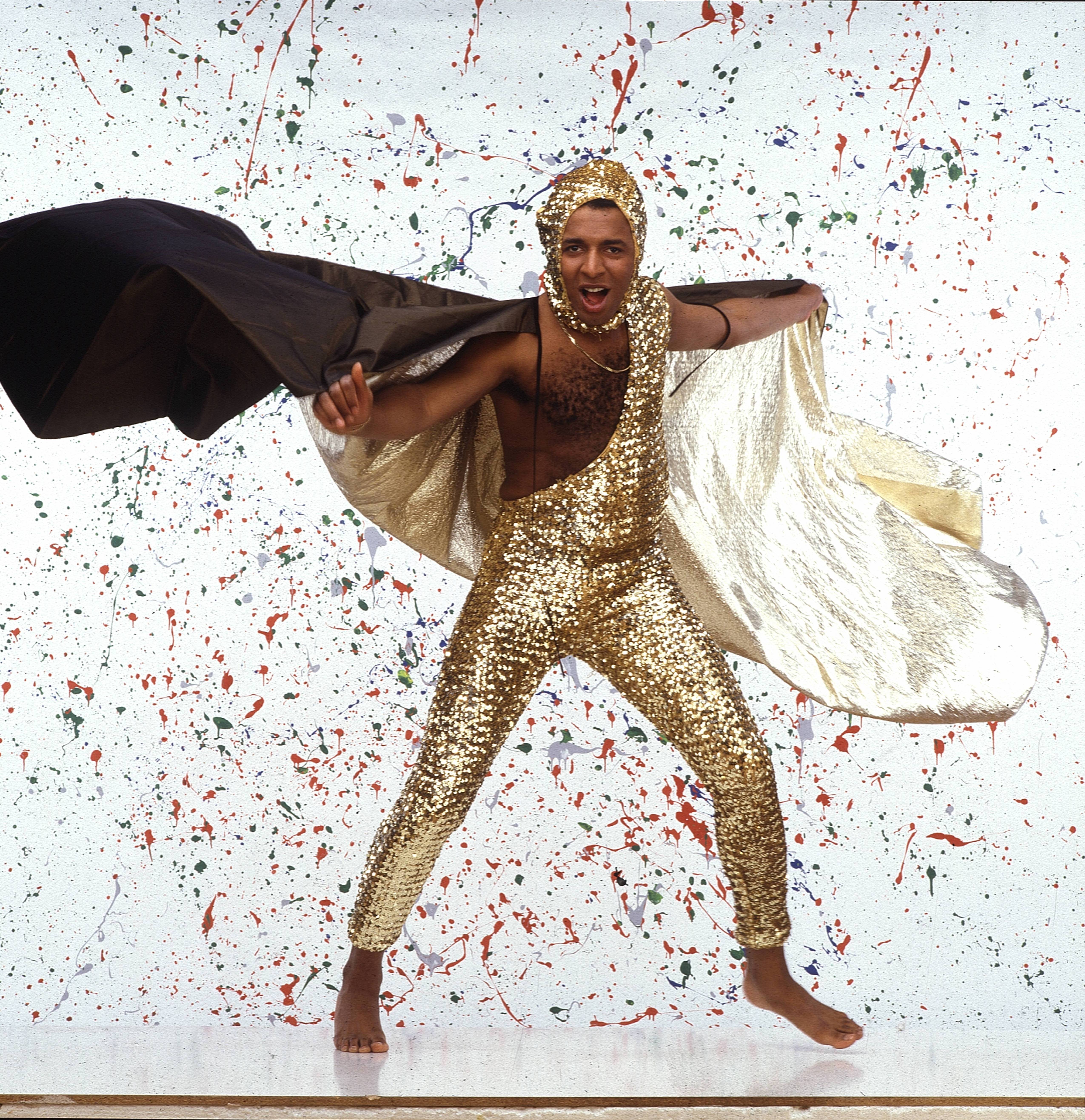 Leee John of Imagination in a gold sequined outfit posing in London.